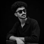 Professional portrait of a digital marketing strategist in Kannur wearing black attire and sunglasses