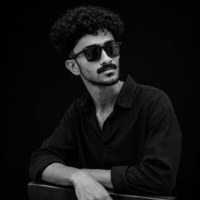 Professional portrait of a digital marketing strategist in Kannur wearing black attire and sunglasses